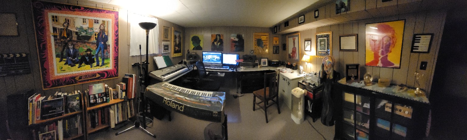 Panoramic view of Michael’s studio with keyboards, a computer recording workstation, shelves of records and books, and music artwork on the walls.